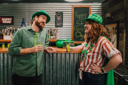 Free Man and Woman Standing at the Bar Holding Green Drinks Stock Photo