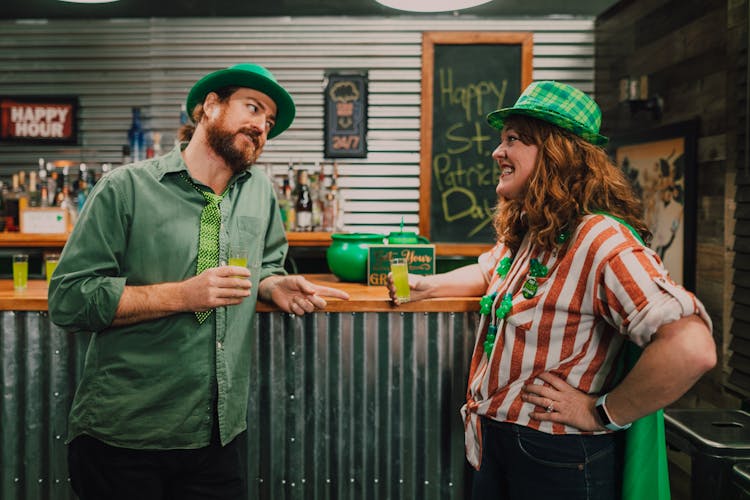 Man And Woman Standing At The Bar Holding Green Drinks