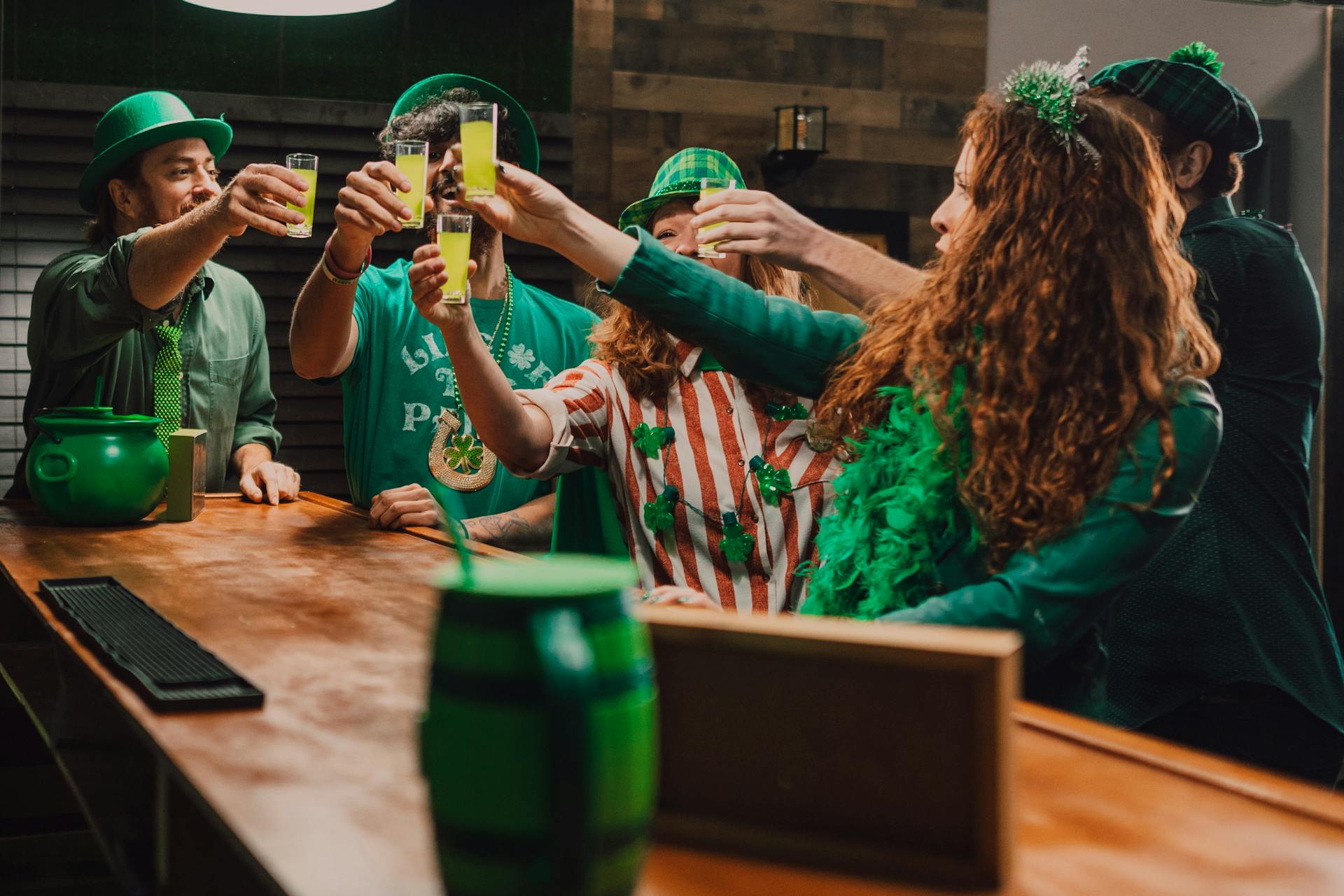 Group of People Clinking Glasses Celebrating St Patrick's Day in a Bar