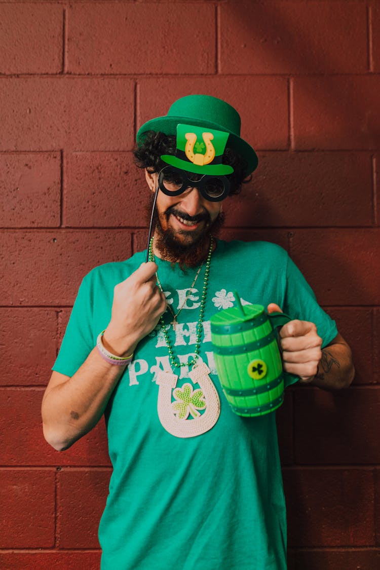 Man In Green Shirt Holding A Mug 