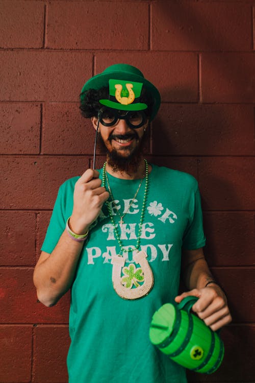 Man in Green Shirt and Hat Holding a Props