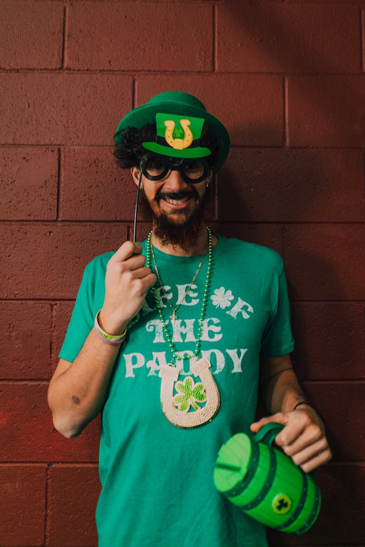 Man In Green Shirt And Hat Holding A Props