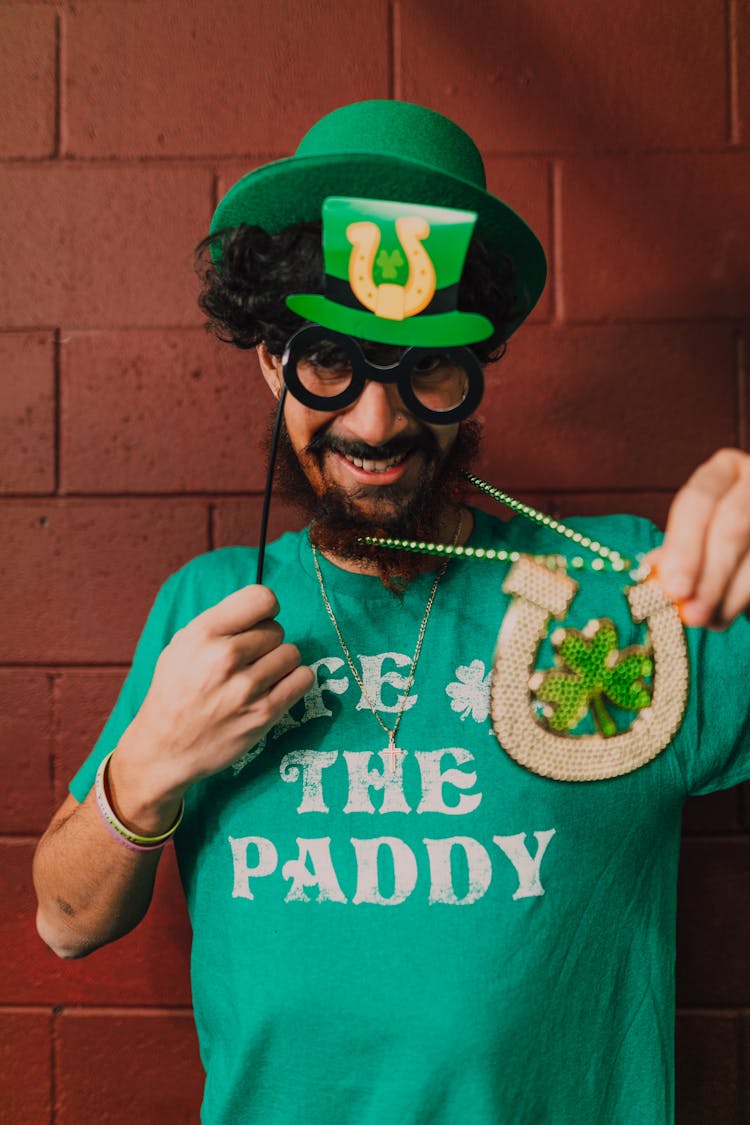 Man In Green Shirt Holding Props And Necklace 