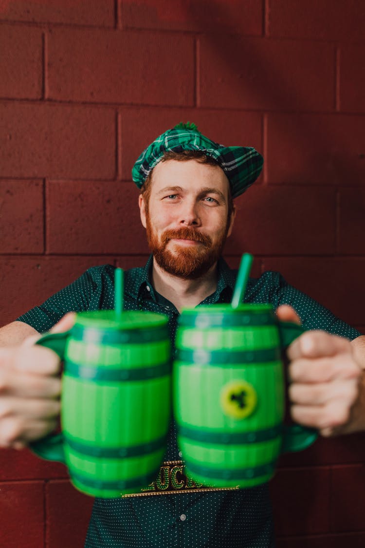 Man Holding Green Drinking Mugs 