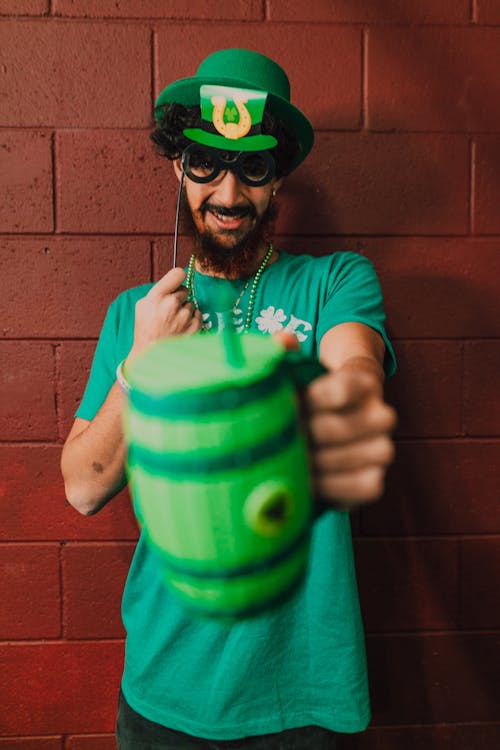 Man in Green Hat Holding a Mug 