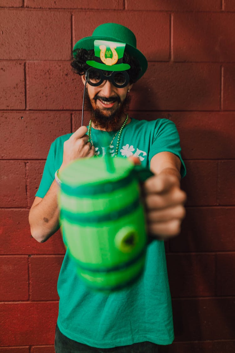 Man In Green Hat Holding A Mug 