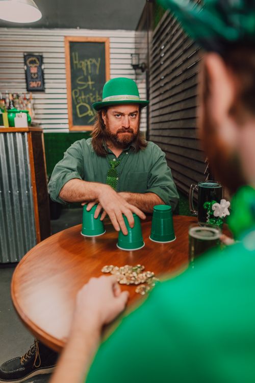Free Two men playing a game with green cups, celebrating St. Patrick's Day indoors. Stock Photo