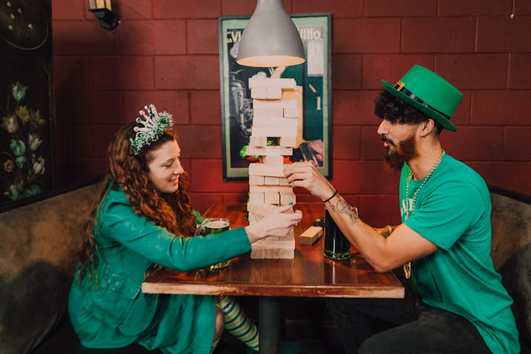 Man And A Woman Playing Jenga Inside A Pub