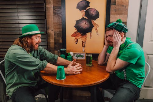 Young male friends playing shell game in pub on Saint Patricks Day