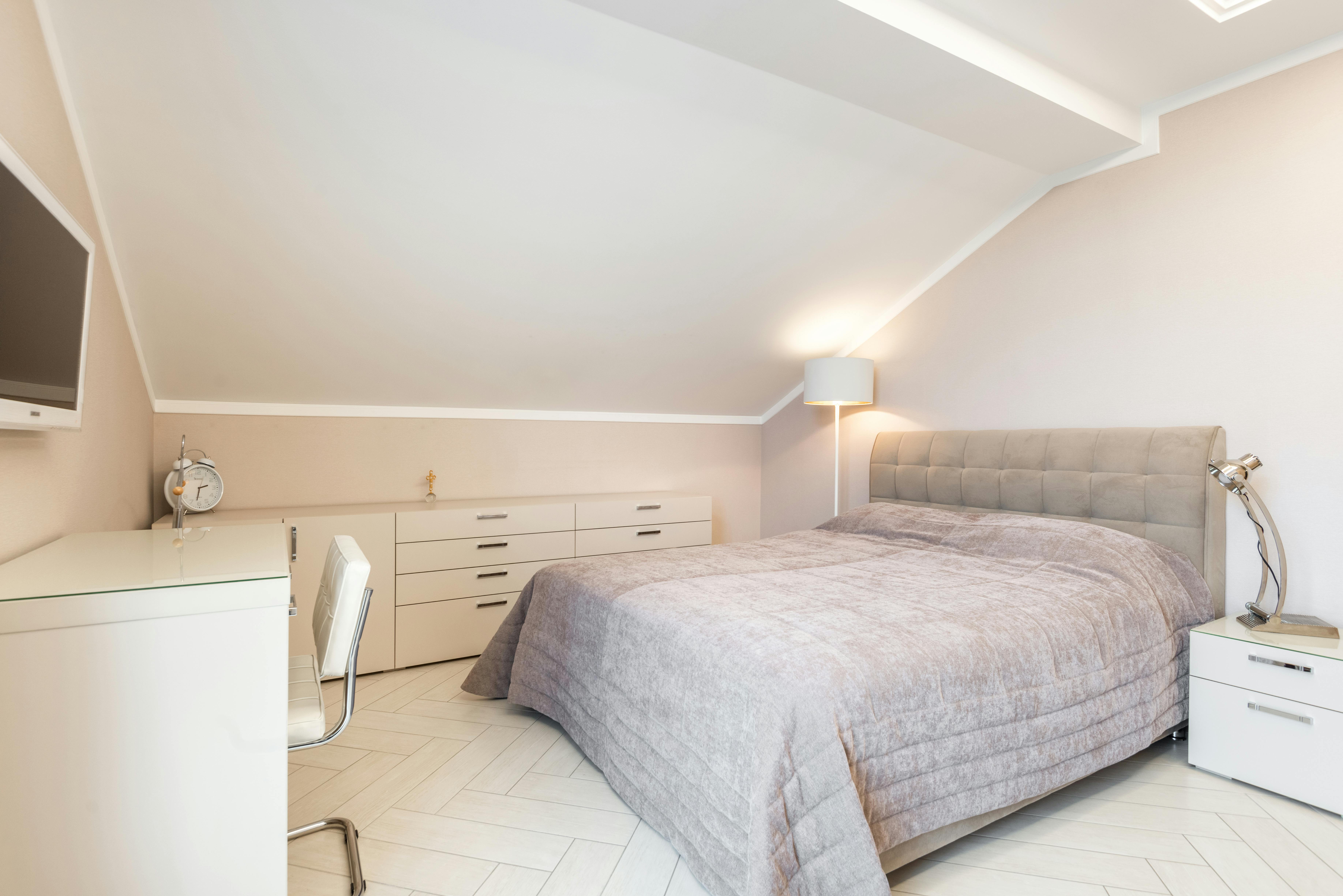 Schlafzimmer im skandinavischen Stil mit klappbarem Wand-Schreibtisch und heller Einrichtung