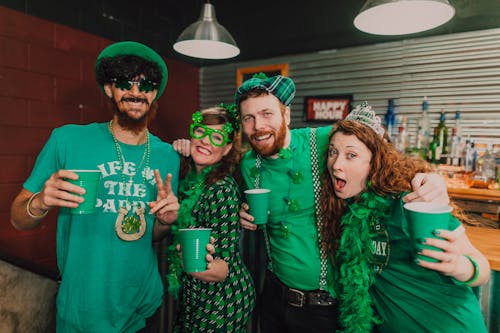 Happy Friends Posing while Holding Green Plastic Cups