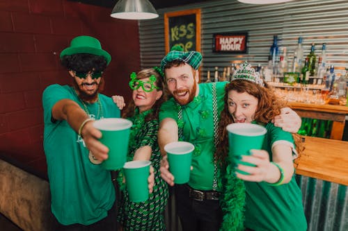 Happy Friends Holding Green Plastic Cups