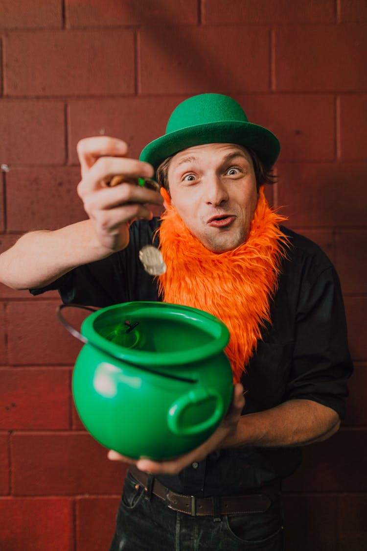 Man In Leprechaun Costume Putting Coins In A Pot