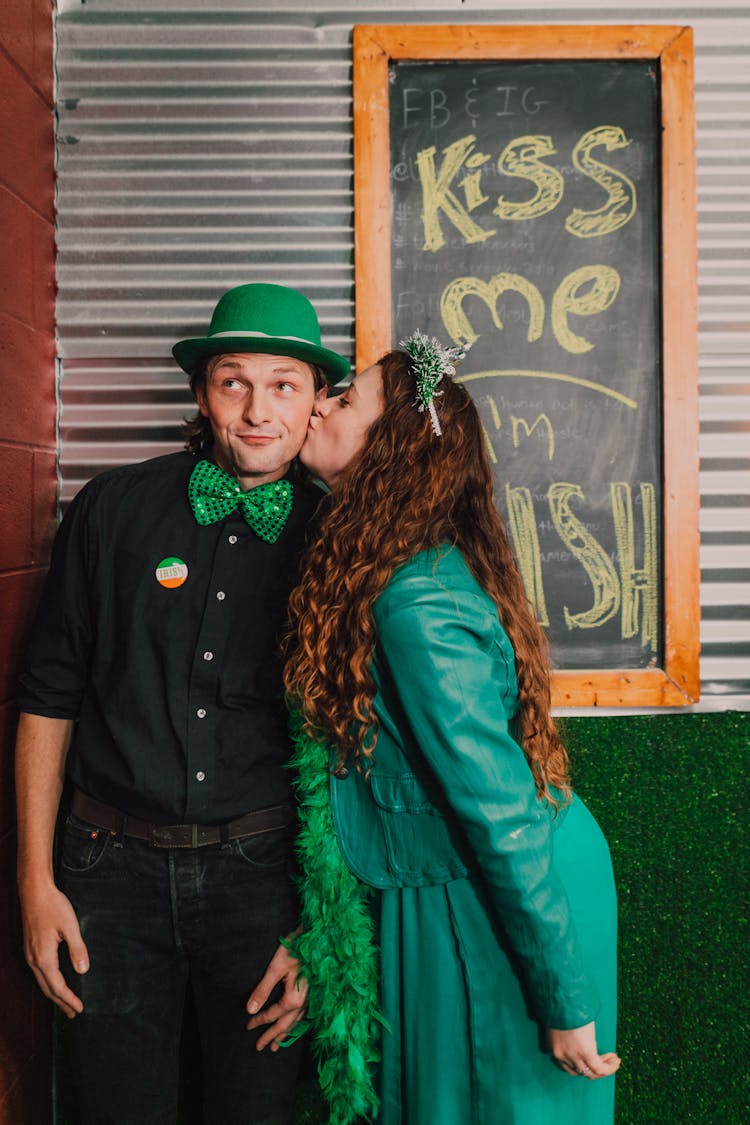 Woman In Green Dress Kissing A Man In Green Hat