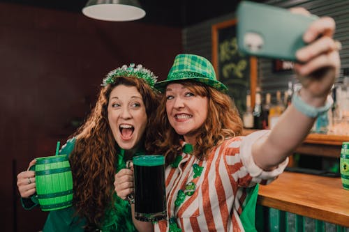 Friends Taking a Selfie while Holding Mugs