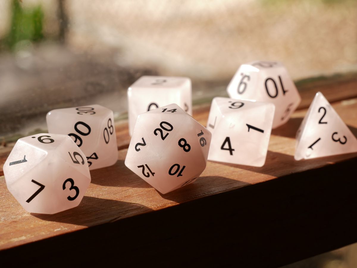 Matte white polyhedral DND dice set on wood surface for storage guide