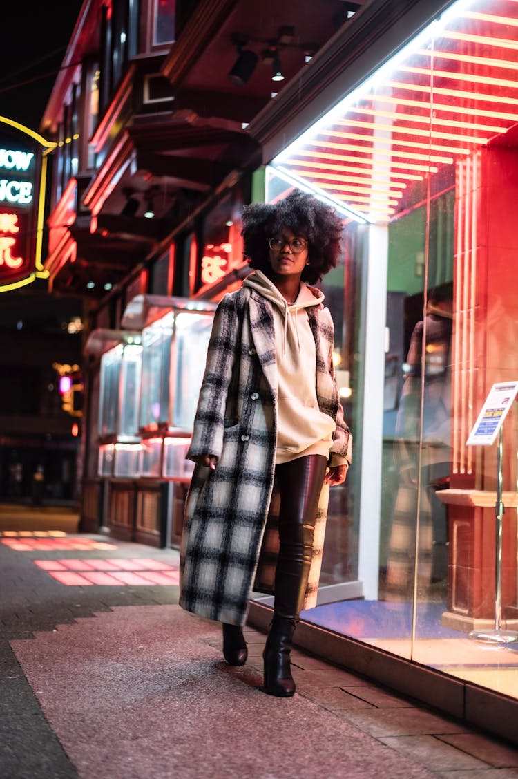 Black Woman At Night Street Near Illuminated Buildings With Windows