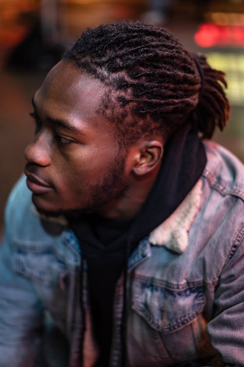 Serious black man with dreadlocks in city