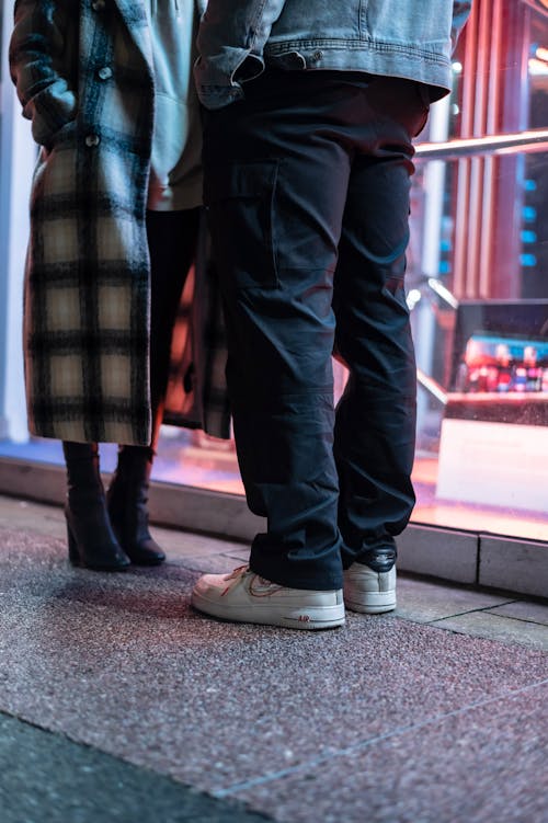 Serious black couple on pathway in evening street · Free Stock Photo