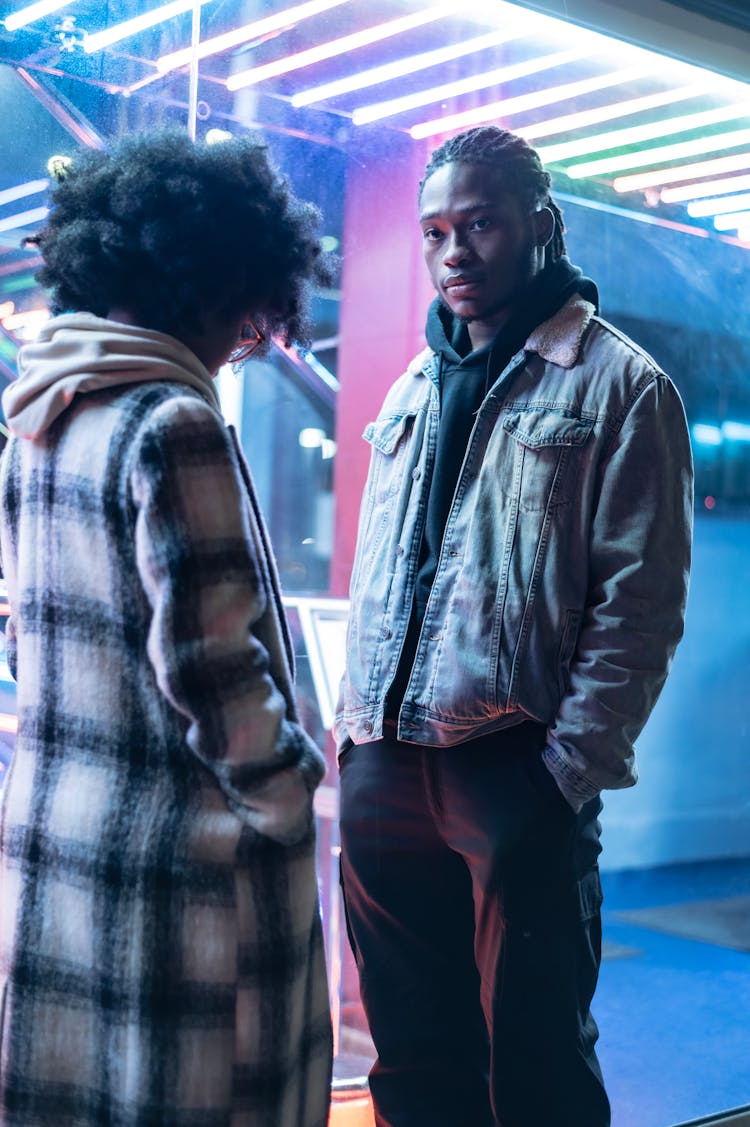 Serious Black Couple Near Illuminated Building