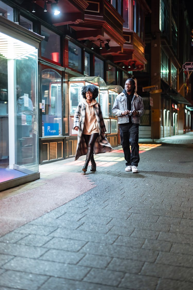 Positive Black Couple Walking On Sidewalk With Photo Camera