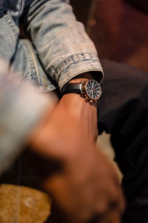 Free From above anonymous African American guy with trendy wristwatch and denim jacket sitting and resting Stock Photo