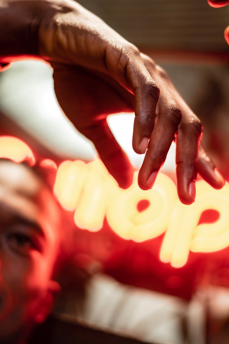 Crop Black Man With Raised Arm Against Neon Title