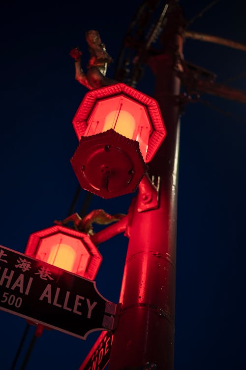 Alley inscription on signboard between neon lanterns in night city