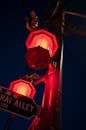 Alley inscription on signboard between neon lanterns in night city