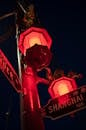 Low angle of inscriptions with numbers and hieroglyphs on signboards under lamps on post in night city