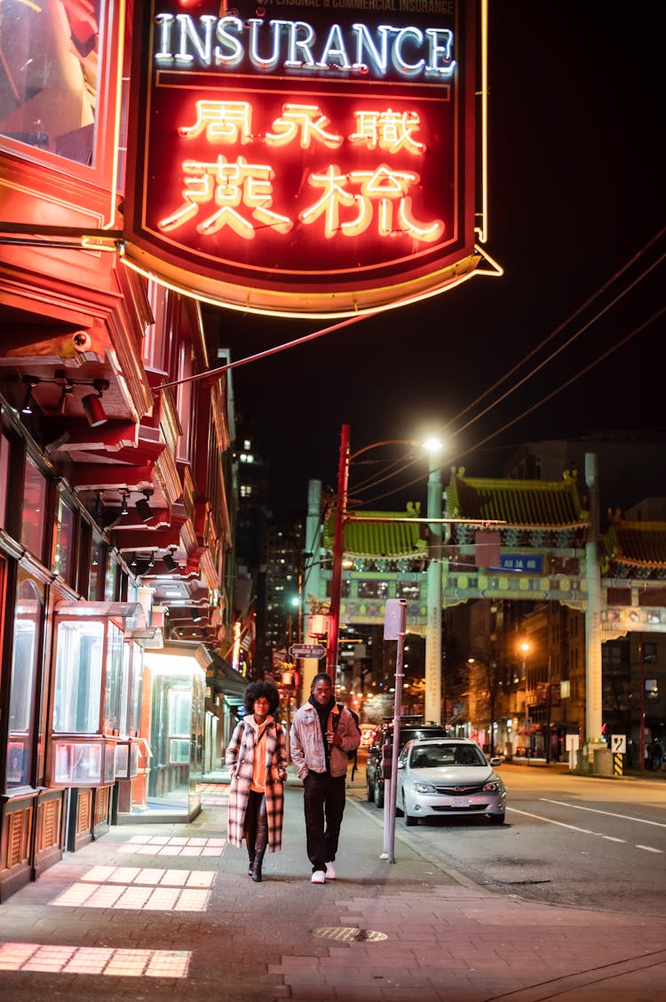 Man And Woman On Sidewalk At Night