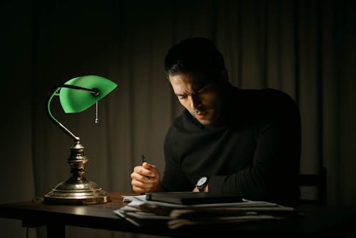 Smart man doing paperwork in dark room