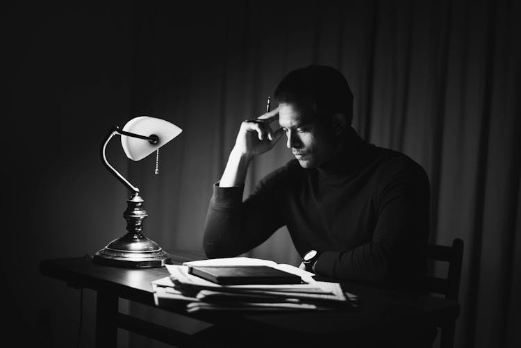 Contemplative Man Reading Book In Classy Home Office