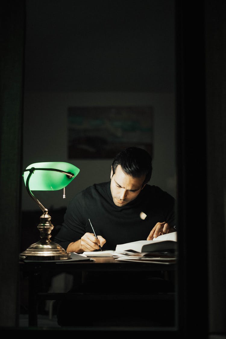 Thoughtful Man Writing In Notebook And Studying In Home Office