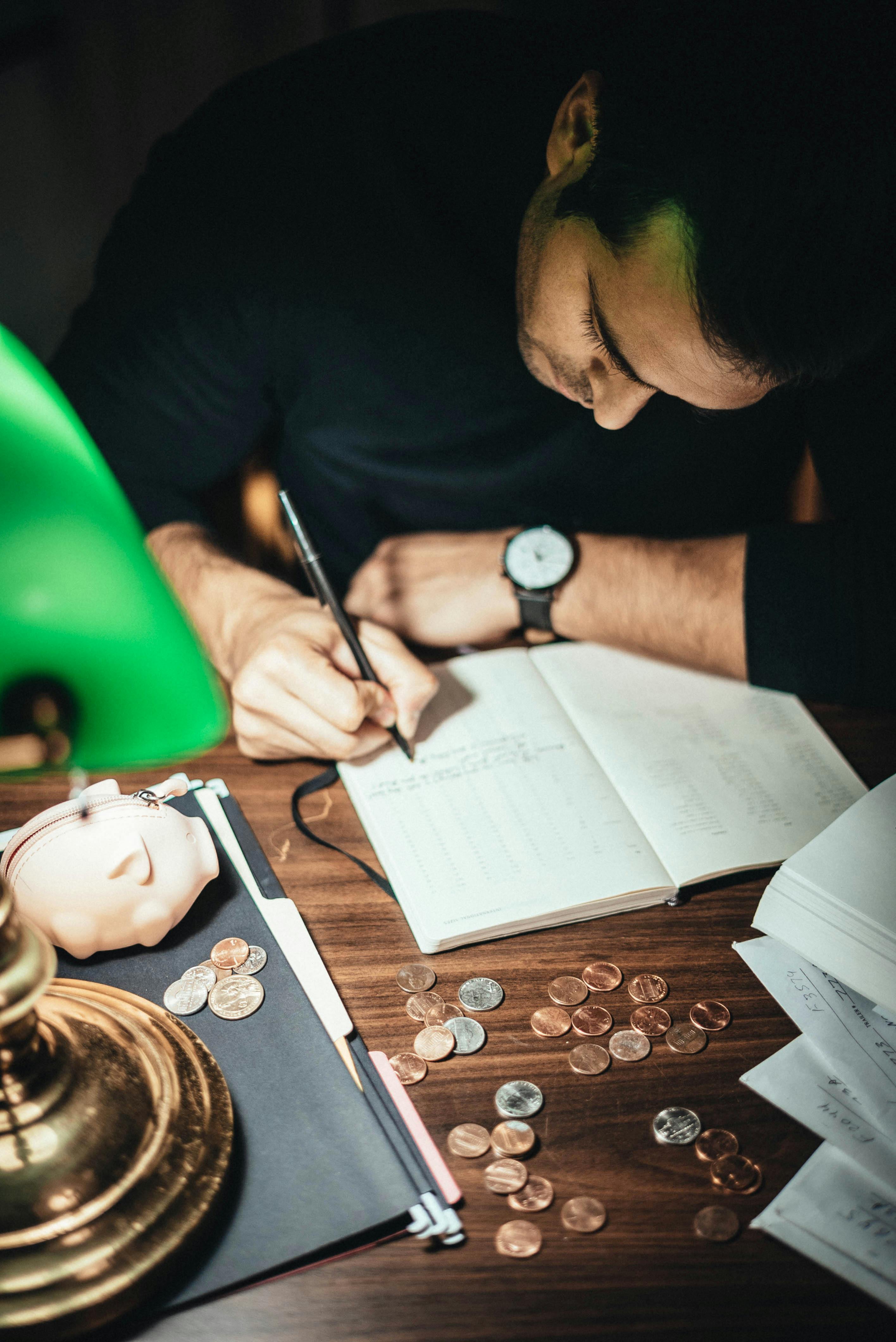 man writing down on a stationery