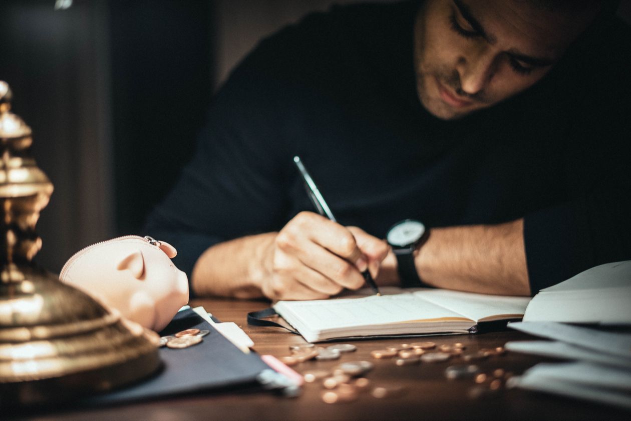 Professional writing in an account book at a desk