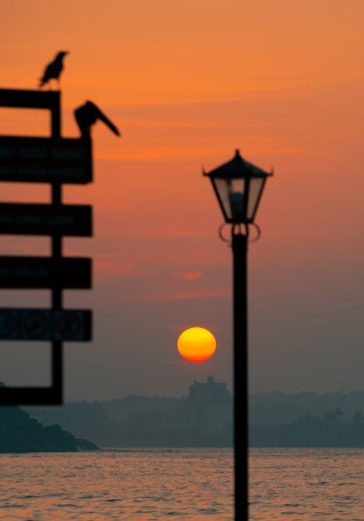 Light Posts Sunset Lamp Post Near Body of Water During Sunset · Free Stock Photo