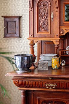 Ornate vintage wooden cupboard displaying dishes and decor in a classic home interior.
