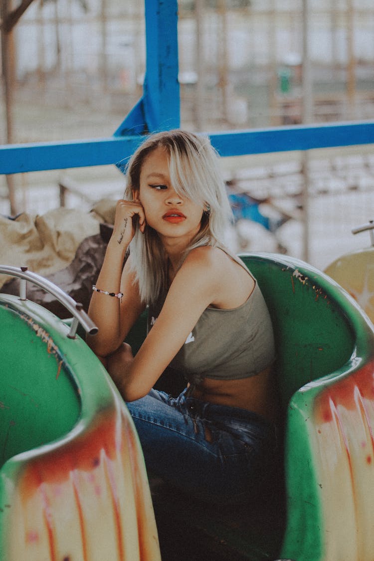 Woman Sitting On Green And Red Roller Coaster