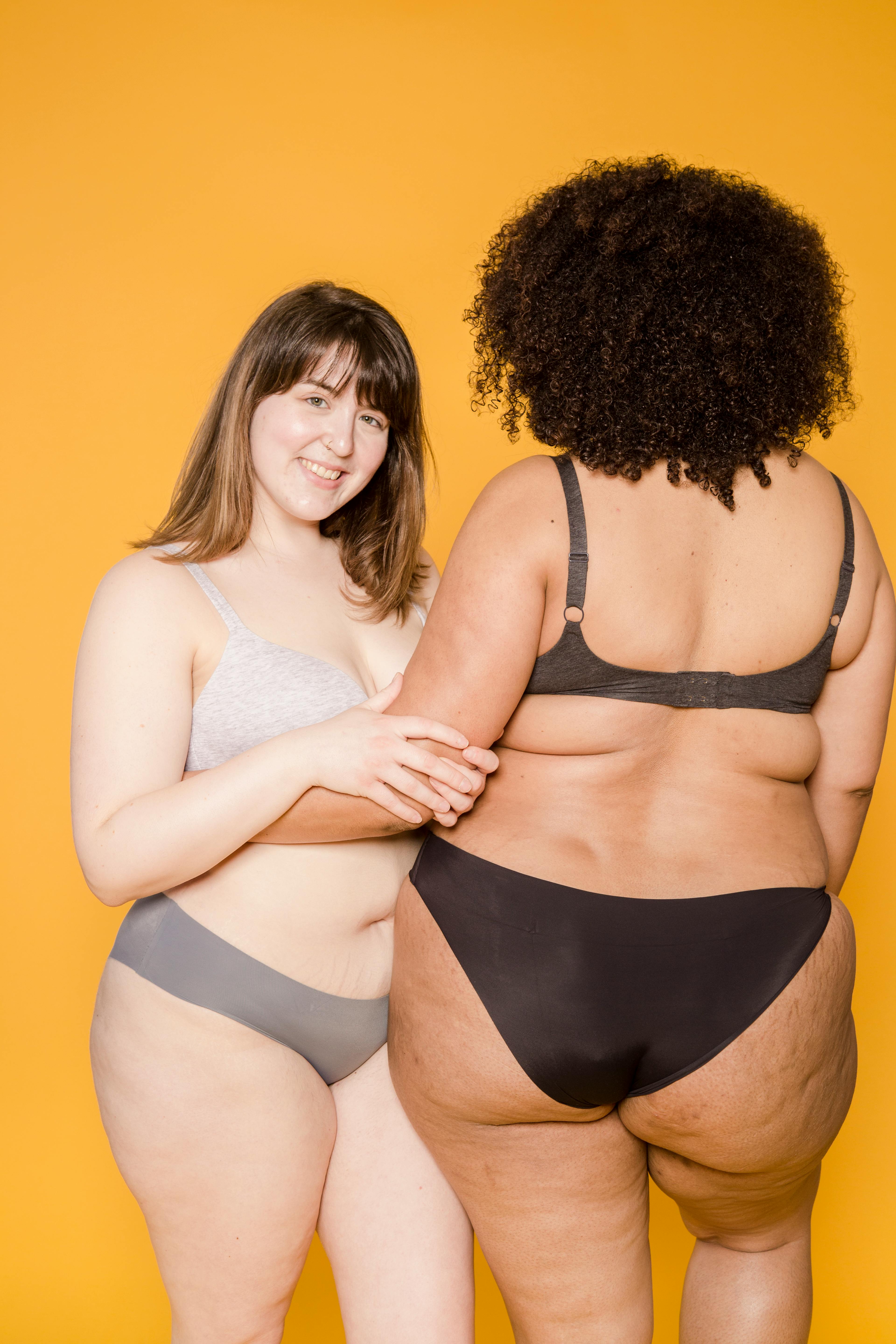 Happy plump Asian woman with anonymous black female in underwear · Free  Stock Photo