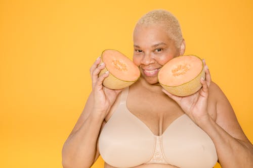 Cheerful plus size African American model with cut melon