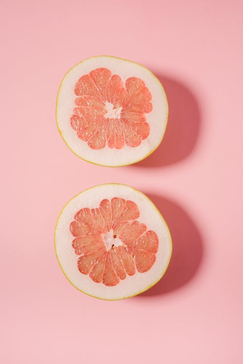 Free Sliced juicy grapefruit on pink surface Stock Photo