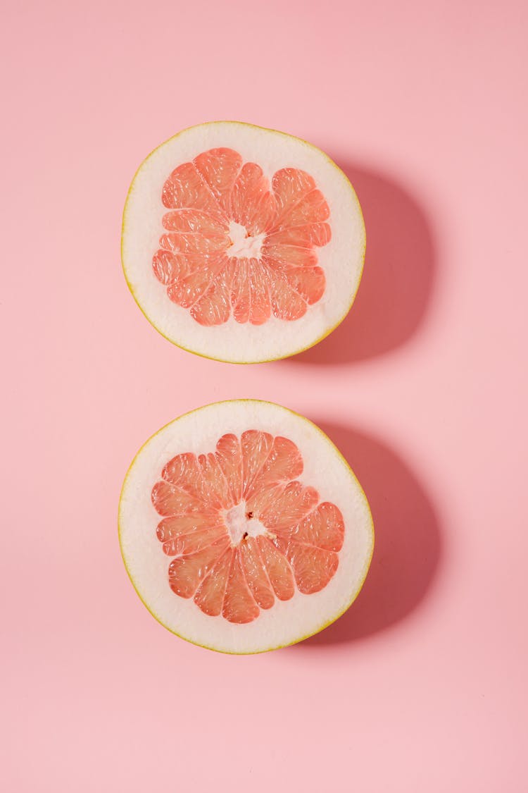 Sliced Juicy Grapefruit On Pink Surface