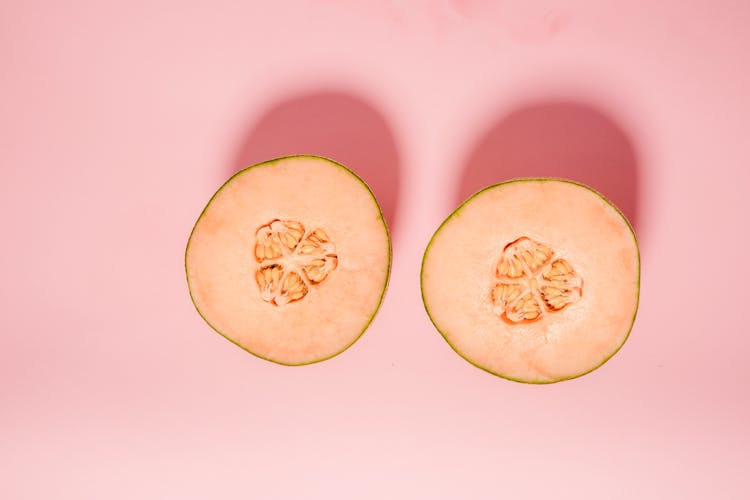 Halves Of Melon On Pink Background