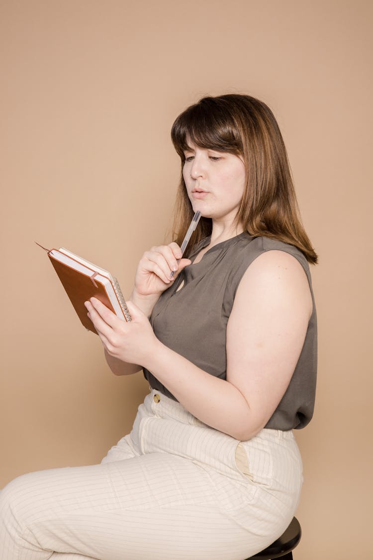 Serious Plump Asian Woman With Notebook