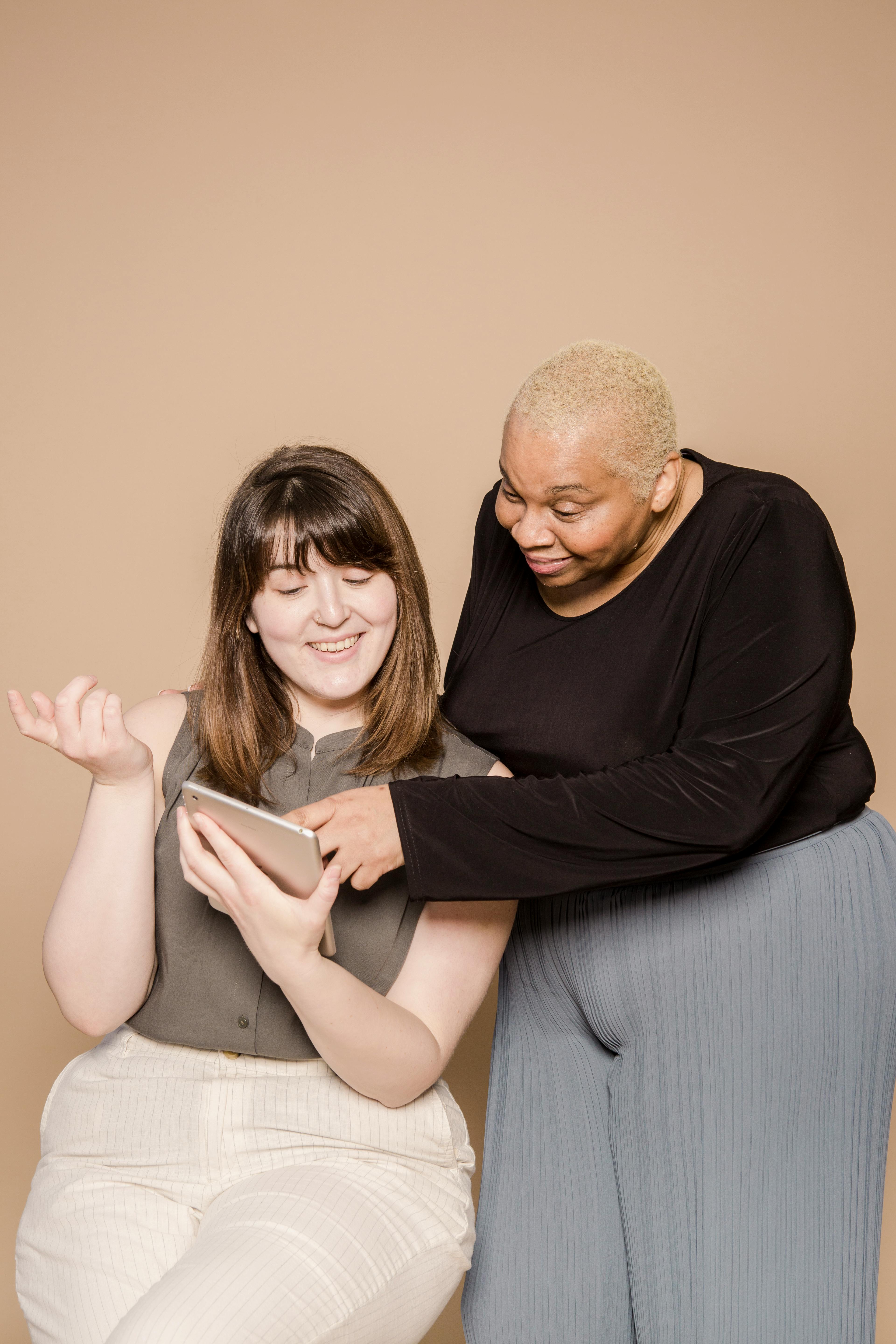 happy overweight diverse women browsing tablet