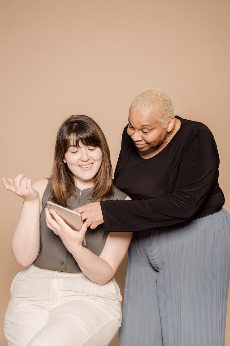 Happy Overweight Diverse Women Browsing Tablet