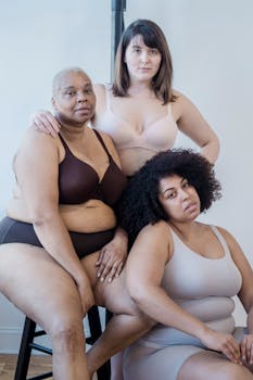 Plus size African American women with young partner in lingerie looking at camera