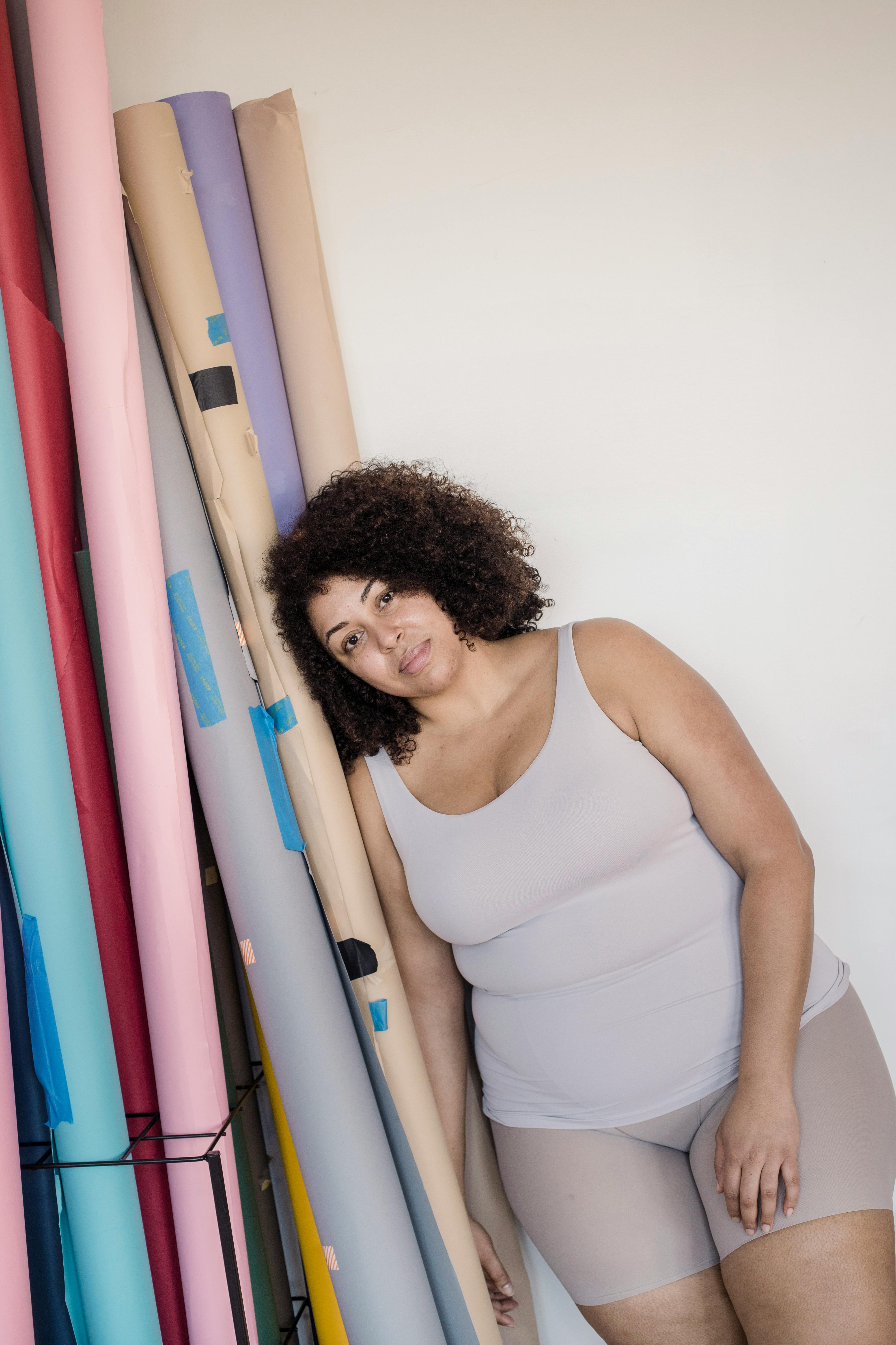 overweight ethnic model in underwear leaning on paper rolls