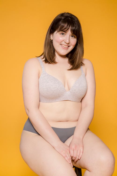 Free Content young overweight female in brassiere and bikini sitting on stool while looking at camera Stock Photo